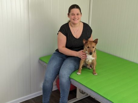 Bild der Besitzerin mit Hund auf Massageliege